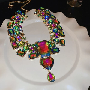 Close-up of golden necklace with iridescent rhinestones in heart and drop shapes on a tray