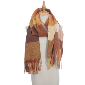 Detail of soft thick checkered scarf with orange and brown plaid pattern and long tassels