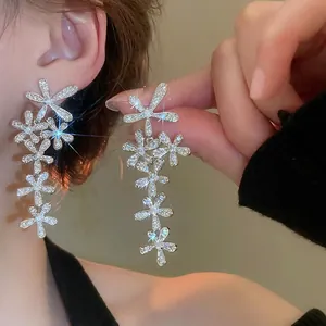 Silver flower tassel drop earrings with sparkling cubic zirconia on a female model