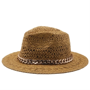 Detail of hand-woven straw jazz hat with golden chain trim and caramel texture
