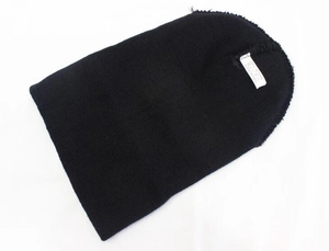 Detail view of the black knit beanie with a label showing 100% acrylic material