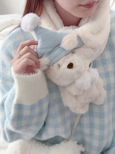 Detail of plush bear scarf in cream white with a cute blue sleeping cap decoration