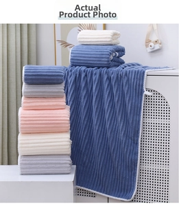 Close-up of coral fleece towel set with vertical textured stripes and woven borders