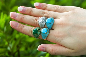 Macro shot of hip hop rings with large colorful zircons and full pavé micro-inlay settings
