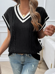 Detailed knit texture and white striped V-neck of a loose black sleeveless sweater vest