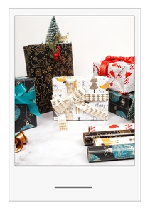 Detailed view of mixed Christmas gift wrapping paper rolls with festive gold and red patterns