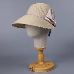 Detailed close-up of natural straw sun hat featuring a large elegant satin bow decoration