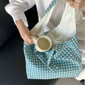 Close-up of blue checkered knit tote bag showing woven texture and interior capacity
