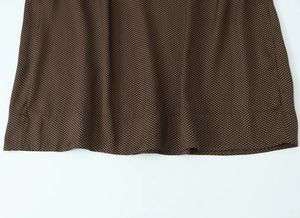 Détail du tissu léger marron foncé à petits pois sur l'ourlet de la robe