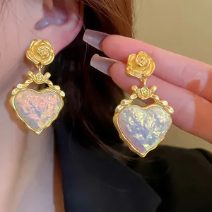 Boucles d'oreilles vintage avec rose gaufrée, nœud et pendentif cœur aux reflets irisés