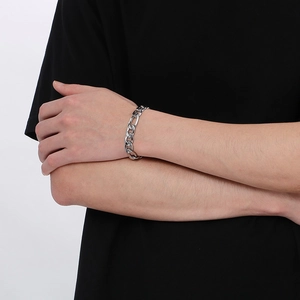 Polished silver Figaro chain bracelet on male wrist for casual titanium steel style