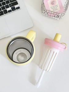 Detailed top view of a yellow 316 stainless steel insulated mug with a pink tea infuser