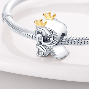 Detailed view of silver letter R charm with golden crown and sparkling zircons