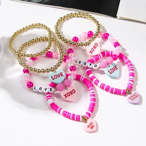 Detail of pink heart charm bracelets with LOVE, XOXO and HUG ME letter charms