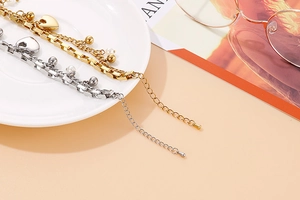 Détail de bracelets cœur multicouches en acier inoxydable avec perles sur plat céramique