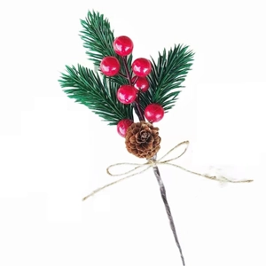 Close-up of Christmas pine needle decoration with red berries, pine cones and hemp rope bow
