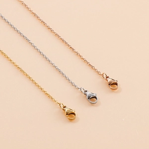 Close-up of lobster clasp and chain links on gold, silver, and rose gold pendants