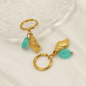 Eleganti orecchini a conchiglia dorati con pietre naturali blu cielo su seta bianca