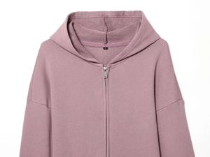 Gros plan du sweat à capuche rose montrant les détails du col et la texture du tissu