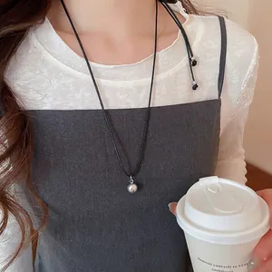 Minimalist silver hollow flower pendant on black cord necklace for a trendy aesthetic look