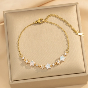 Elegant gold star bracelet featuring opal stones and zircons on a champagne satin background