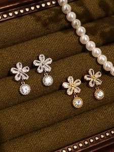 Détails de boucles d'oreilles fleurs en or 18k et argent avec zircons 5A dans un coffret