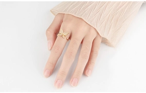 Detail of golden butterfly spinner ring with clear zircon crystals on model hand