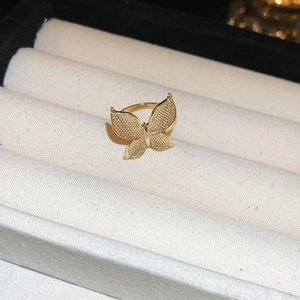 Macro shot of gold butterfly ring with matte wings in a velvet jewelry gift box