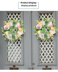 Detail of pink and yellow spring floral wreaths with printed porcelain plates on wooden doors
