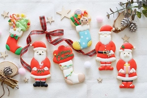 Flat lay of Christmas cookies with Merry Christmas frosting on white textured fabric