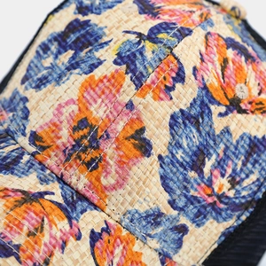 Close-up of tropical floral print on breathable straw trucker hat for summer sun protection