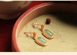 Detailed macro view of vintage gold plated earrings with Hetian jade on a jewelry box