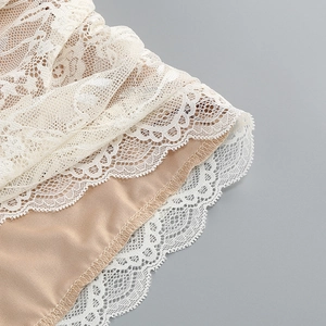 Detailed close-up of white lace embroidery and multi-layer hemline on party dress