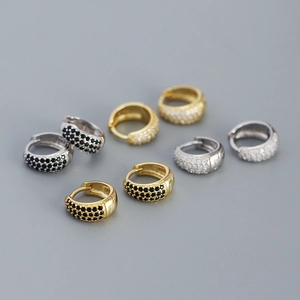 Detail of 925 silver U-shape huggie earrings with micro-set black and white zircons