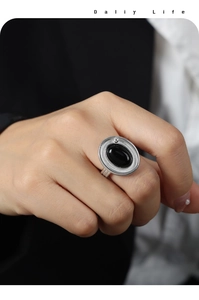 Détail d'une bague double en argent avec une grande agate noire ovale portée au doigt