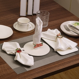 Christmas napkin rings with elk and wreath designs on a festive holiday table setup