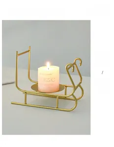 Detailed view of a golden metal sleigh candle holder with a white pillar candle on it