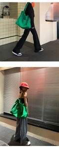 Street style view of a green canvas tote bag featuring a large capacity minimalist design
