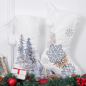White faux rabbit fur Christmas stockings with snowflake and forest embroidery on mantle