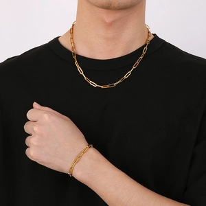 Minimalist gold tone rectangular paperclip link chain necklace and bracelet set on a model