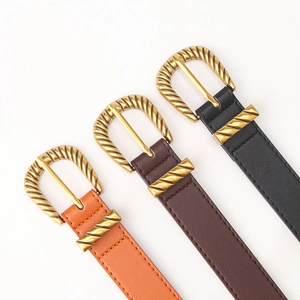 Three pieces of vintage leather belts for women in orange, brown and black with gold buckles