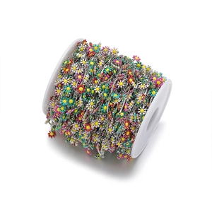 Macro detail of colorful enamel daisy chain spool for DIY jewelry making and necklace crafts
