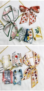 Detailed close-up of patterned silk hair scarves featuring premium stitching and labels