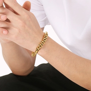 Close-up of a gold skull charm bracelet for men, featuring a sleek metallic finish
