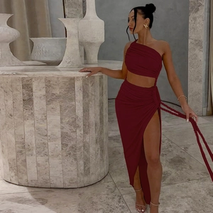 Detail of burgundy one-shoulder ruched crop top and high slit skirt set in soft knit