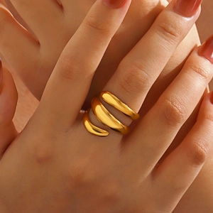 Polished gold spiral wrap open ring with minimalist layered design worn on finger
