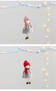 Close-up of pink and red plush ornaments with knitted hats on white branches