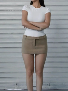 Detail of slim-fit white short sleeve t-shirt and khaki mini skirt on a model