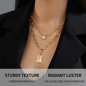 Détail du collier chaîne dorée multicouche avec perle blanche et pendentif portrait