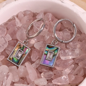 Detail of silver steel earrings with natural abalone shell and zircon on pink crystals
